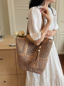 Large woven straw tote bag with tassel charm and tulip detail for beach vacations