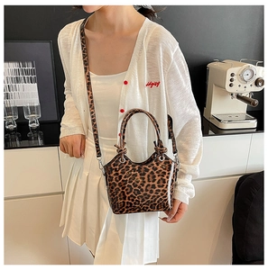 Detail of leopard print bucket bag featuring knotted handles and silver metal hardware