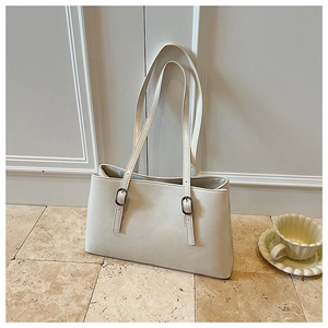 Detail of creamy white faux leather tote bag with silver adjustable buckle and strap