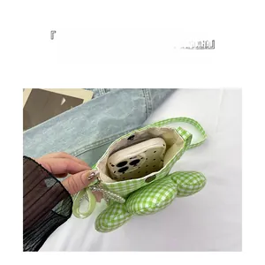 Detail of green plaid canvas bag interior with pearl strap and smartphone storage