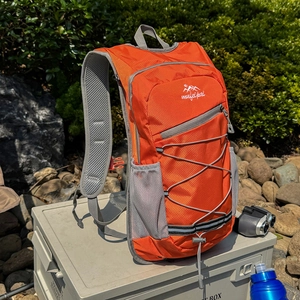 Orange lightweight outdoor sports backpack with breathable mesh straps and bungee cords
