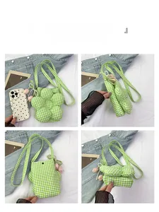 Detail view of flower-shaped green checkered crossbody bucket bag with pearl tulip charm