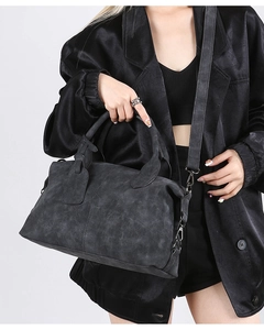 Detail of dark grey suede boston bag showing the matte texture and charcoal metal hardware