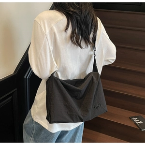 Détail d'un grand sac bandoulière noir ajustable avec logo BNT gaufré et texture unique