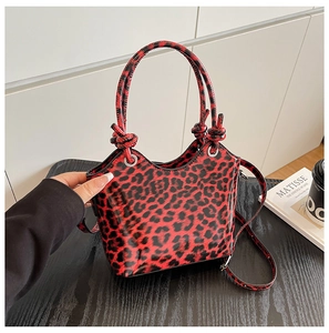 Detail of red leopard print handbag with knotted handle and silver metal hardware