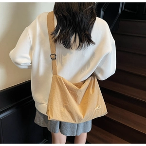 Détail de la bandoulière réglable noire et du sac cabas en toile kaki avec logo BNT