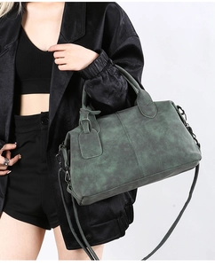 Detailed macro view of dark green retro pillow bag with matte texture and metallic hardware