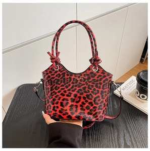 Close-up of red leopard print handbag in glossy patent leather with top handle