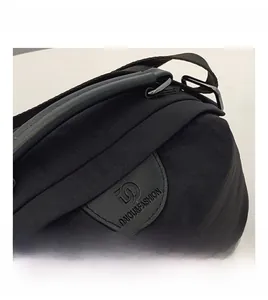 Dettaglio borsa a tracolla in nylon nero con patch logo in pelle e manico