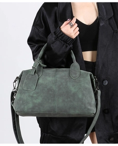 Detail of vintage dark green crossbody bag with matte texture and sturdy handles