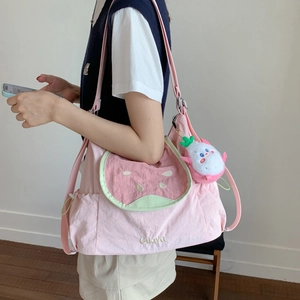 Détail du sac à bandoulière en toile rose avec poche pastèque et broderie de goyave