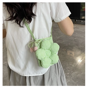 Detail of green and white checkered flower bucket bag worn by model over the shoulder