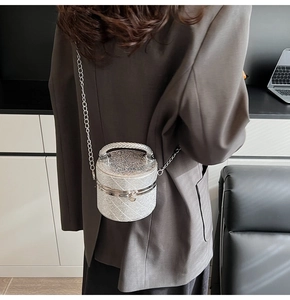 Detail showing shiny silver sequin texture and metallic chain on mini cylinder bag