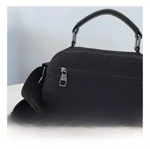 Dettaglio della tasca posteriore con zip e del manico di una borsa in nylon nero