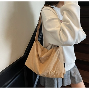 Détail du sac bandoulière en nylon kaki avec broderie BNT et large sangle réglable
