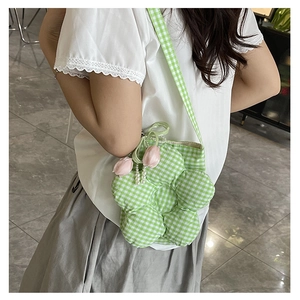 Close-up of green checkered flower-shaped bag with pearl and tulip charms