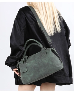 Detailed close-up of dark green Boston bag with soft matte leather and top handles