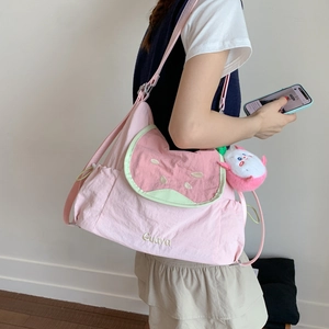 Détail du sac à bandoulière rose en forme de pastèque avec broderie Guava et charme peluche