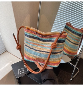Détail d'un sac seau tissé coloré avec des lanières en cuir marron et une étiquette