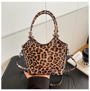 Close-up of leopard print handbag with knotted handle and glossy patent leather finish