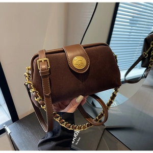 Detail of vintage brown suede bag with gold embossed buckle and chunky metal chain