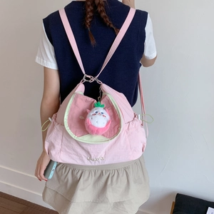 Détail du sac à dos rose à cordon avec lettrage Guava et petit pendentif en peluche