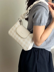 Chic checkered crossbody bag with woven rope strap shown on a model in a minimal setting