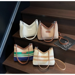 Collection of hand-woven bucket bags in various colors on wooden steps with leather straps