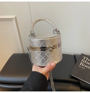 Detailed close-up of a silver glitter cylinder bag with quilted pattern and metal clasp