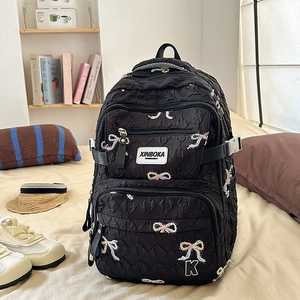Detail of black quilted backpack with embroidered colorful bows and multi-pocket structure