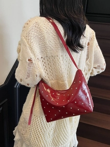 Deep red rivet hobo bag in glossy leather, fashion shoulder bag for women on model