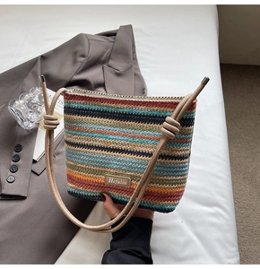 Détail d'un sac seau en paille tissée colorée avec rayures et bandoulière en corde