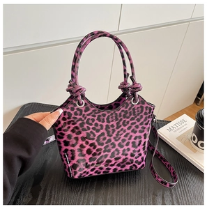Close-up of purple leopard print handbag featuring glossy finish and silver metal rings