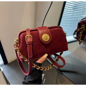 Close-up of wine red matte leather doctor bag with gold chain strap and relief buckle
