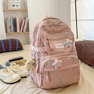Detailed view of a pink backpack with sequins bow, star patches and plush moon charm