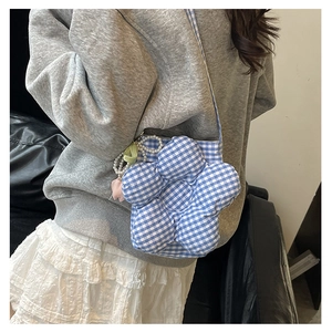 Detail of blue plaid floral bucket bag with pearl chain and colorful charm accessories