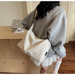 Vue détaillée d'un grand sac cabas en toile blanche avec broderie BNT sur le devant