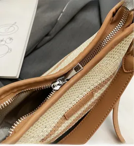 Detail shot of smooth silver metal zipper and brown leather trim on woven bag