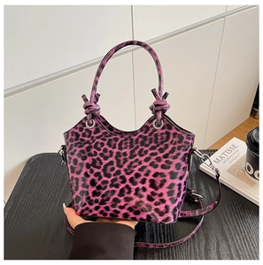 Detail of purple leopard print handbag with knotted handle and glossy patent leather finish