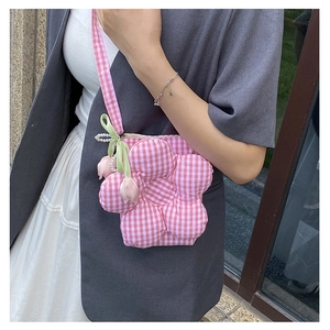 Detailed side view of pink plaid flower crossbody bag with tulip charm on a model