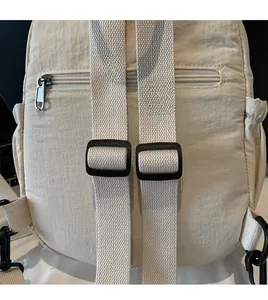 Close-up of adjustable beige nylon shoulder straps and buckle on casual travel backpack