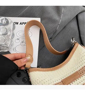 Close-up of woven straw handbag featuring brown leather handles and brand logo patch