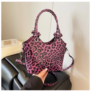 Detail of purple leopard print handbag featuring glossy leather texture and knotted handles