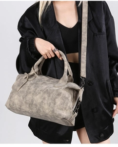 Detailed texture of smoke gray vintage Boston bag with adjustable canvas shoulder strap