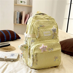 Detail of yellow pleated backpack with star embroidery and white moon plush charm