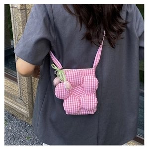 Detail of pink and white checkered flower-shaped canvas crossbody bag with green ribbon bow