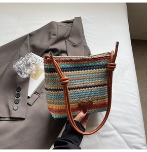 Vue détaillée du sac seau tissé arc-en-ciel avec lanière en cuir et étiquette de marque