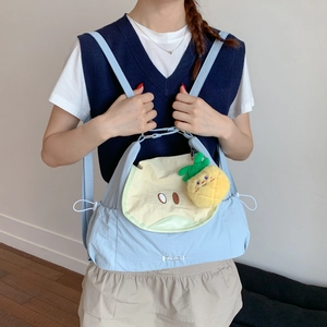 Vue détaillée du sac à dos bleu clair avec broderie poire et charmant pendentif ananas