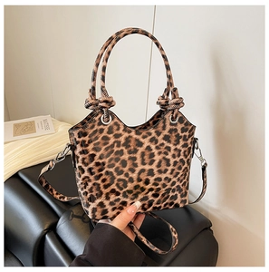 Detail shot of glossy leopard print handbag with double-knot handles and silver hardware