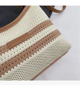 Close-up of striped knit tote bag with brand logo tag and premium woven texture details